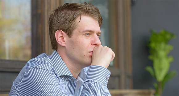 man in striped shirt thinking contemplative moment outdoor setting